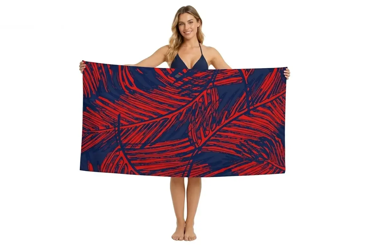 Full-coverage red and navy leaf artwork across a rectangular beach towel