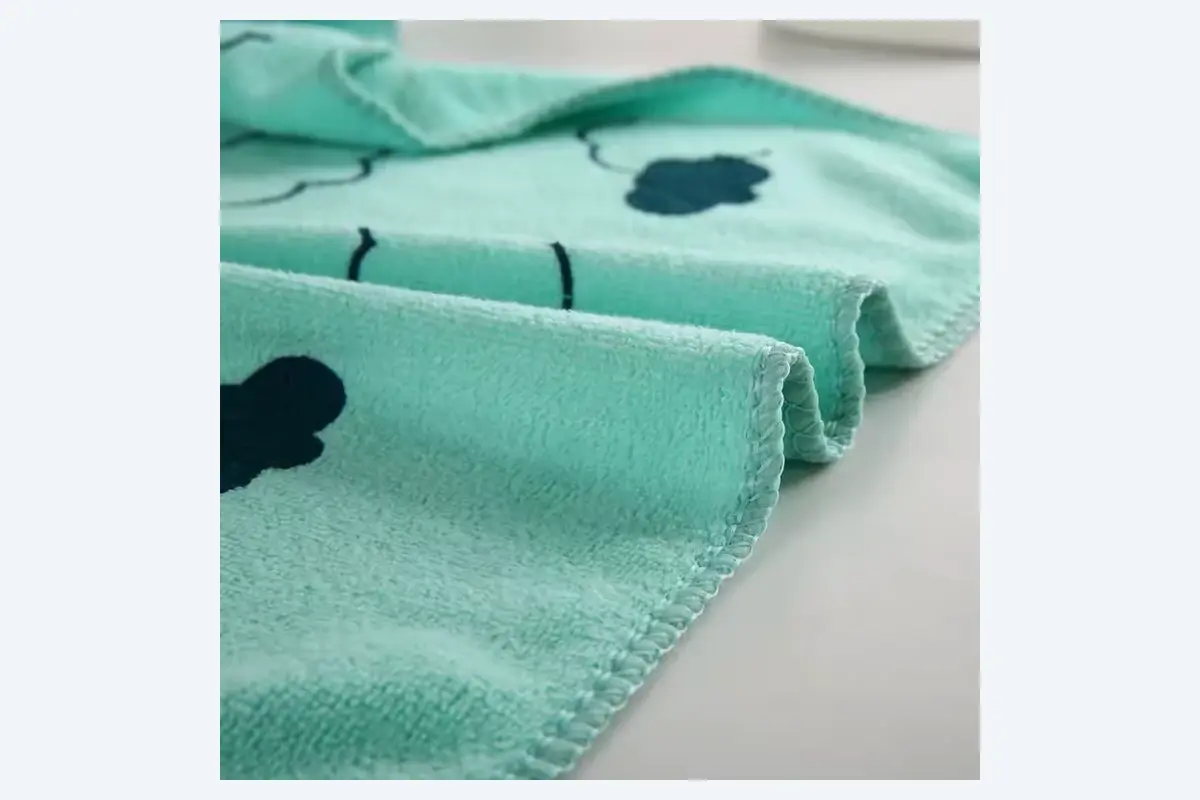 Smooth sheared velour face towel surface with a finished edge